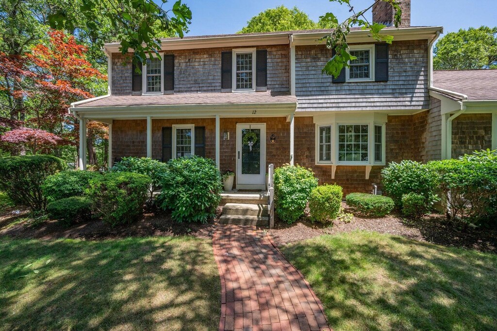 view of front facade with a chimney and a front yard