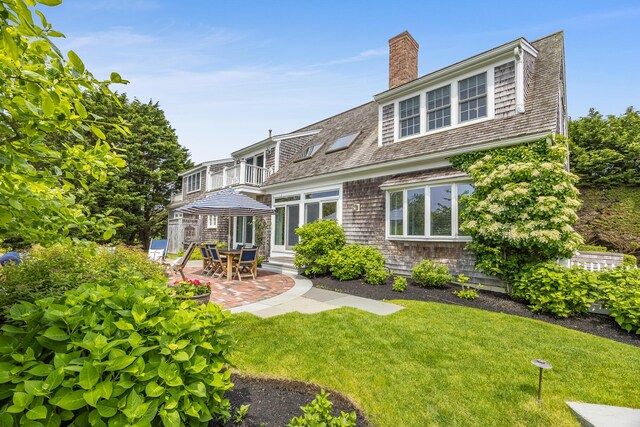 86 Champlain Rd, Chatham, MA 02633 - back of property featuring a balcony, a yard, a patio area, and a chimney