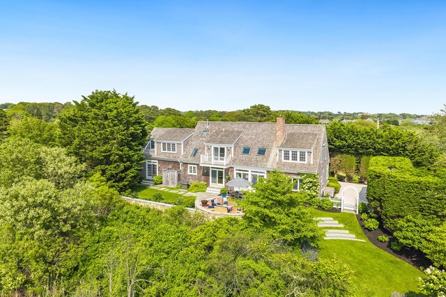 86 Champlain Rd, Chatham, MA 02633 - back of property featuring a chimney, a gambrel roof, a patio, and a lawn