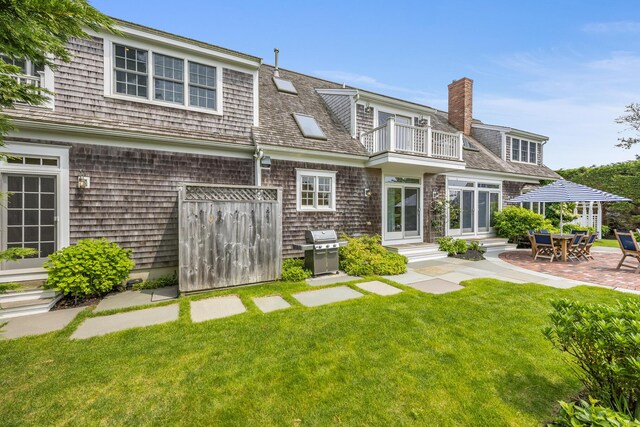 86 Champlain Rd, Chatham, MA 02633 - rear view of property with a balcony, a lawn, a chimney, and entry steps