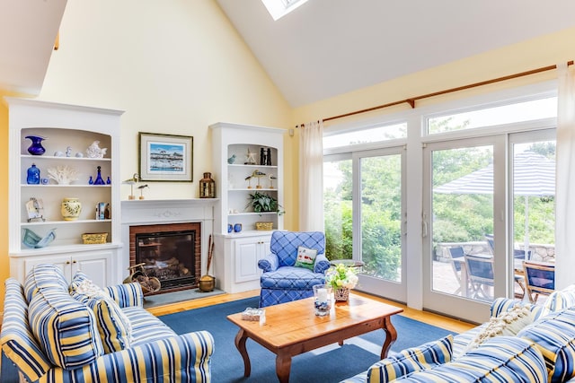 86 Champlain Rd, Chatham, MA 02633 - living room featuring wood finished floors, high vaulted ceiling, a fireplace, and a skylight