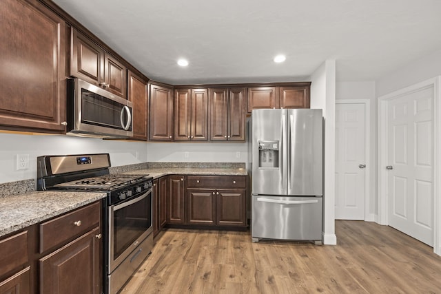 57 Melgo Ln, South Yarmouth, MA 02664 - kitchen with appliances with stainless steel finishes, light wood-style floors, dark brown cabinetry, light stone counters, and recessed lighting