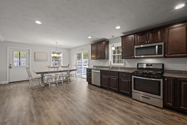57 Melgo Ln, South Yarmouth, MA 02664 - kitchen with appliances with stainless steel finishes, dark brown cabinetry, a sink, a chandelier, and dark wood-style flooring