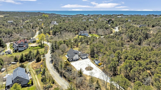 drone / aerial view of a heavily wooded area and a nearby body of water