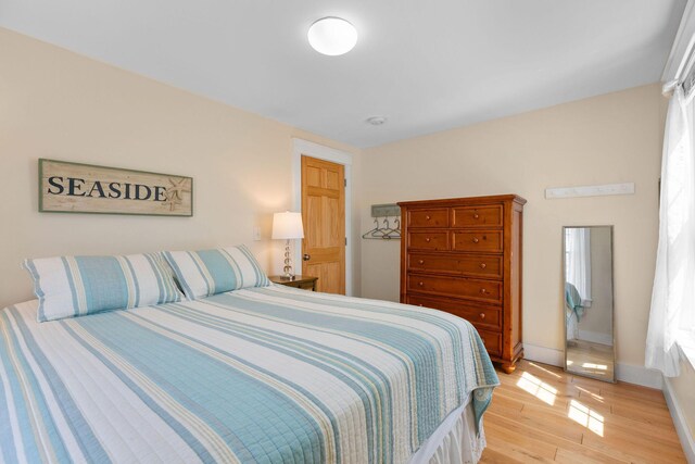 bedroom with light wood-style flooring and baseboards