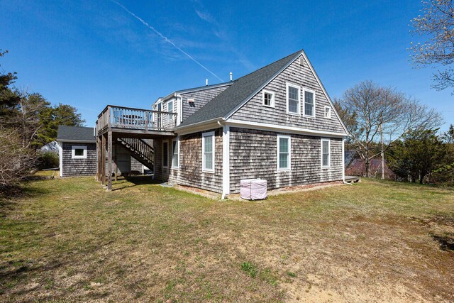 back of property featuring stairs, a wooden deck, and a lawn
