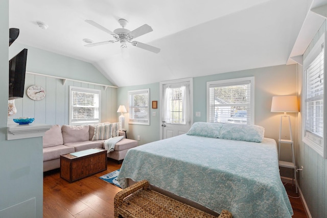 bedroom featuring lofted ceiling, wood finished floors, multiple windows, and ceiling fan