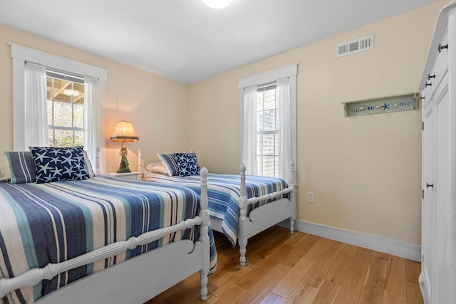 bedroom featuring light wood-style floors and baseboards