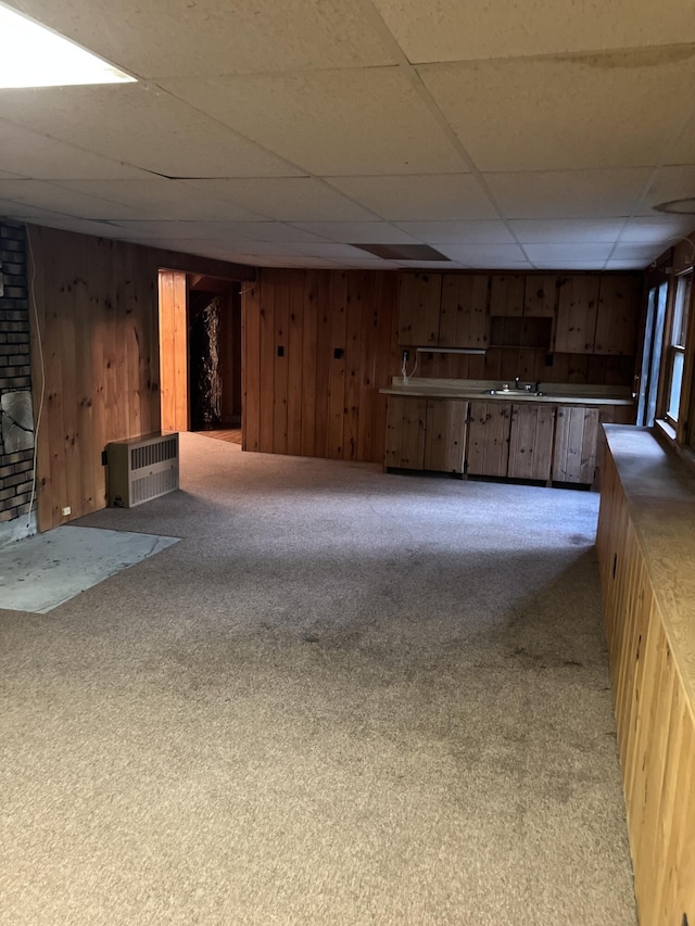 1094 County Rd, Pocasset, MA 02559 - unfurnished living room featuring wood walls, a drop ceiling, and carpet