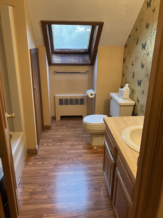 1094 County Rd, Pocasset, MA 02559 - full bath featuring radiator, a skylight, wood finished floors, vanity, and a tub