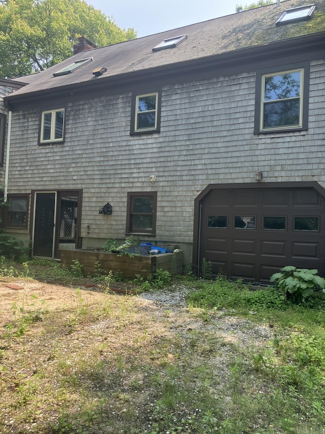 1094 County Rd, Pocasset, MA 02559 - rear view of house with a garage and a chimney