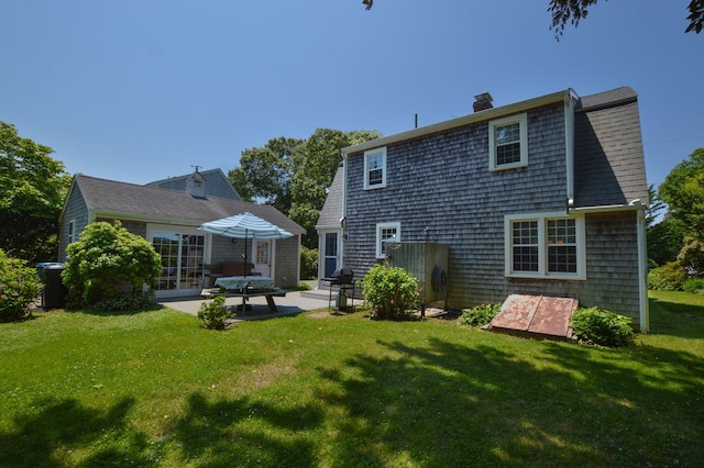 110 Teaticket Path, East Falmouth, MA 02536 - rear view of house with a patio area, a chimney, and a yard