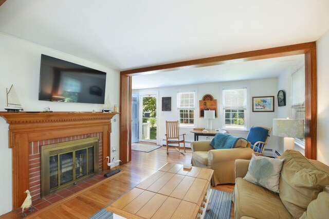 110 Teaticket Path, East Falmouth, MA 02536 - living area with wood finished floors, a brick fireplace, and baseboard heating