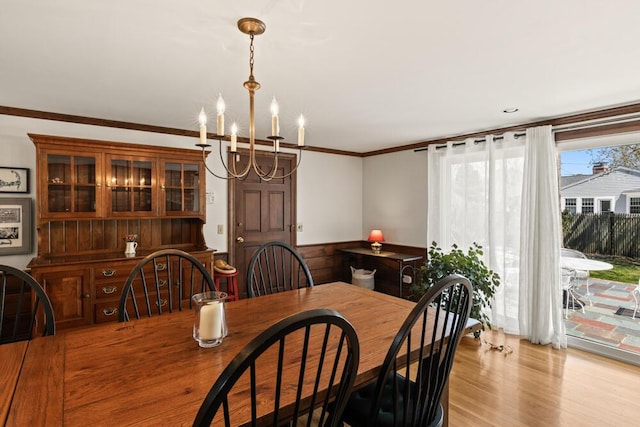 56 Fairwood Rd, South Yarmouth, MA 02664 - dining area with light wood-style floors, crown molding, a notable chandelier, and wainscoting