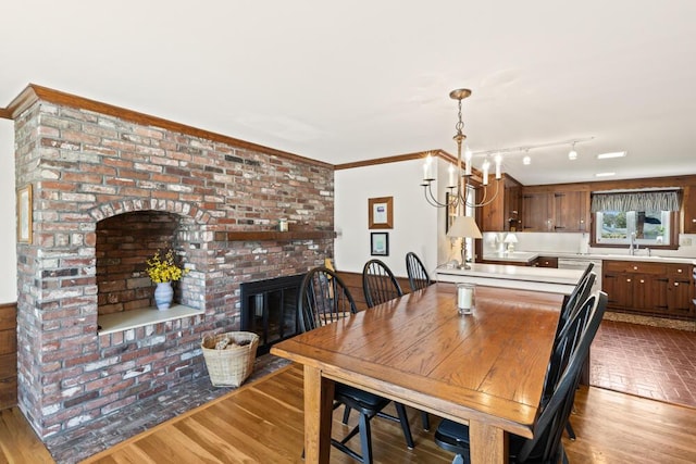 56 Fairwood Rd, South Yarmouth, MA 02664 - dining area with wood finished floors, a brick fireplace, and a chandelier