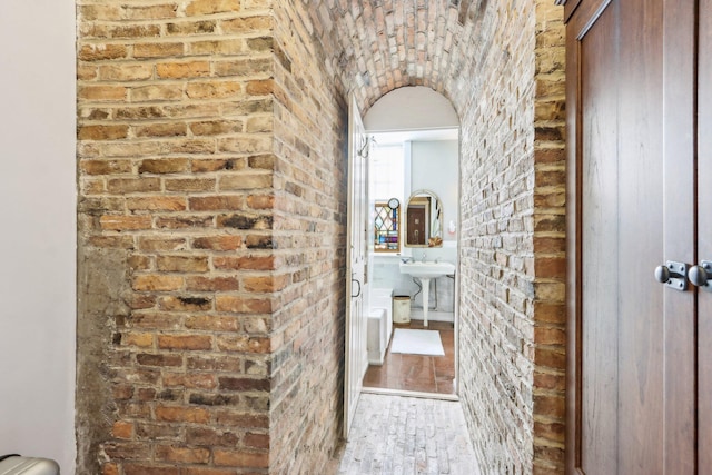 100 Eliot St, Natick, MA 01760 - hall featuring sink, hardwood / wood-style flooring, and brick wall