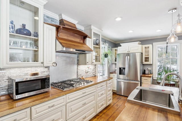 100 Eliot St, Natick, MA 01760 - kitchen with decorative light fixtures, sink, white cabinets, ornamental molding, and stainless steel appliances