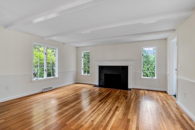 31 John Joseph Rd, Harwich, MA 02645 - unfurnished living room featuring light wood-style flooring, beam ceiling, plenty of natural light, and a fireplace