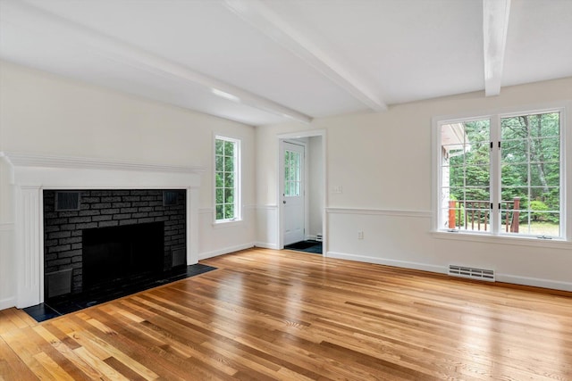 31 John Joseph Rd, Harwich, MA 02645 - unfurnished living room featuring hardwood / wood-style flooring, beamed ceiling, and a brick fireplace