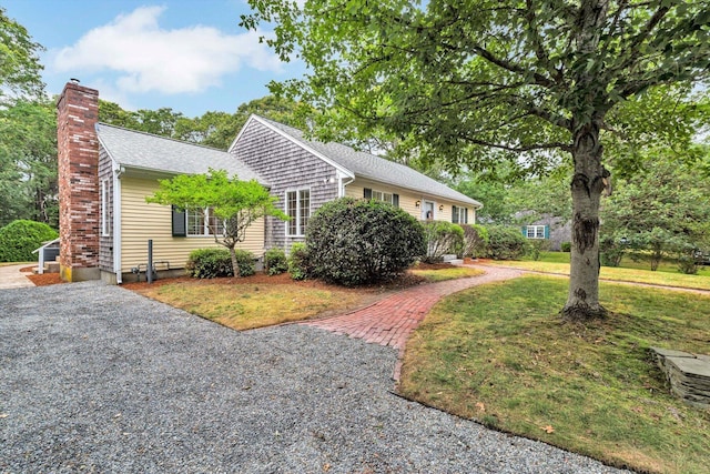 31 John Joseph Rd, Harwich, MA 02645 - view of front facade featuring a chimney, a front yard, and a shingled roof