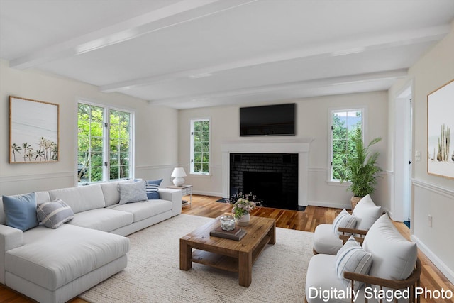 31 John Joseph Rd, Harwich, MA 02645 - living area featuring wood finished floors, beam ceiling, healthy amount of natural light, and a brick fireplace