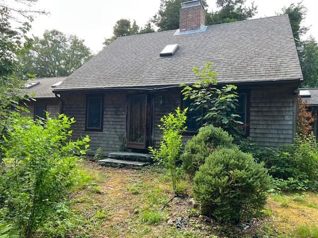10 Hemenway Ct, Eastham, MA 02642 - view of front of property featuring roof with shingles and a chimney