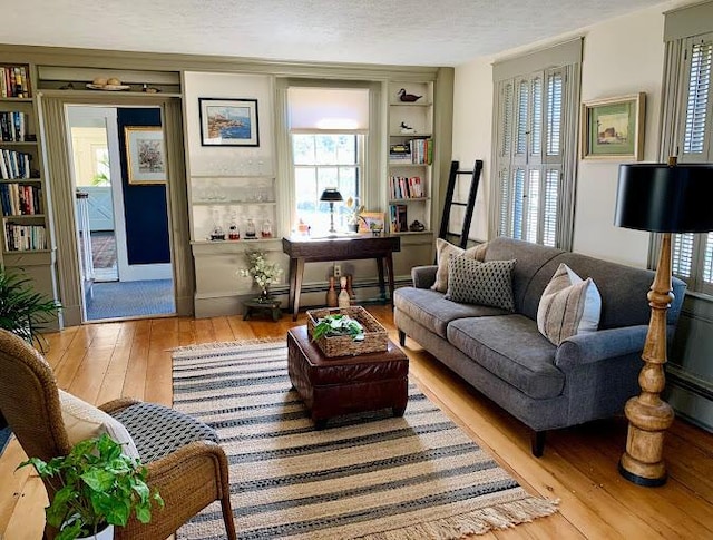 living area with built in features, a textured ceiling, and a wealth of natural light