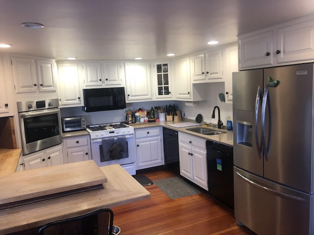 kitchen featuring sink, white cabinets, dark hardwood / wood-style flooring, and black appliances