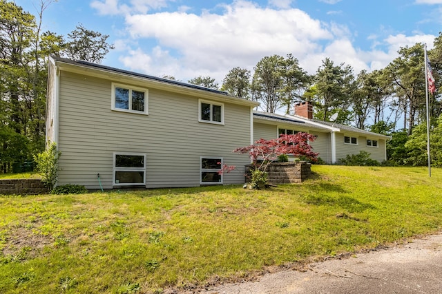 218 Center St, South Dennis, MA 02660 - view of home's exterior featuring a chimney and a lawn