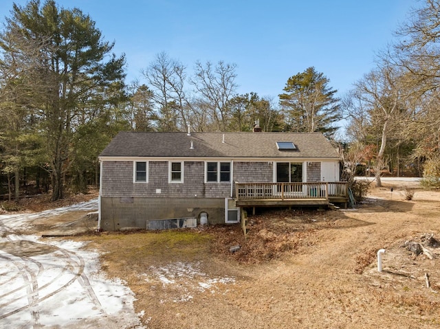 back of house with a shingled roof and a deck