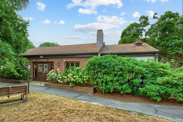 rear view of property featuring french doors, a chimney, a vegetable garden, and brick siding