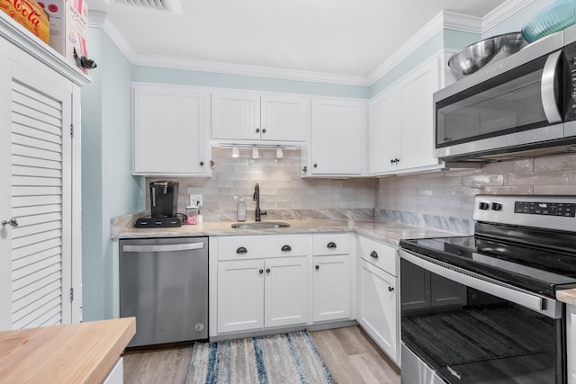 kitchen with a sink, white cabinetry, appliances with stainless steel finishes, and light wood-style flooring