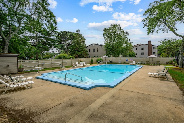 pool with a patio and fence