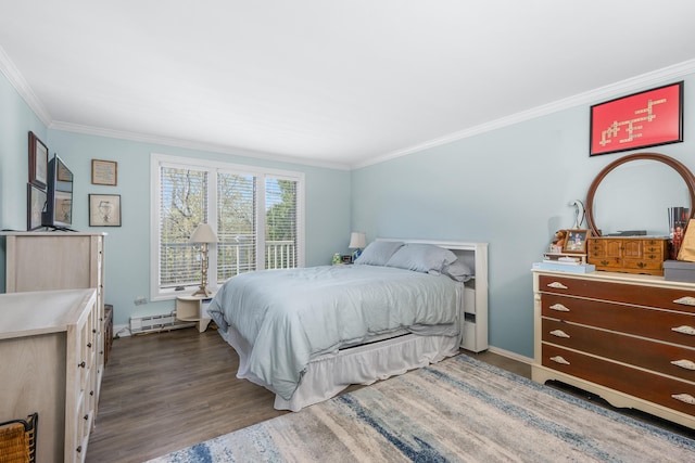 bedroom featuring crown molding, baseboards, baseboard heating, and wood finished floors
