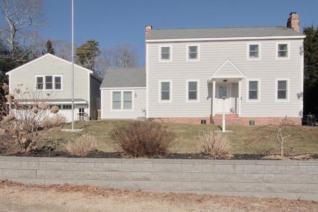 colonial house featuring crawl space, a chimney, and a front yard