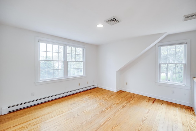 additional living space featuring a baseboard heating unit, wood finished floors, baseboards, and recessed lighting