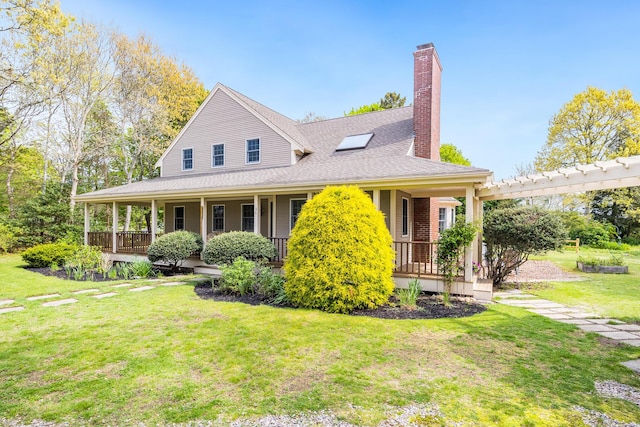 farmhouse inspired home with a porch, a front lawn, a chimney, and roof with shingles