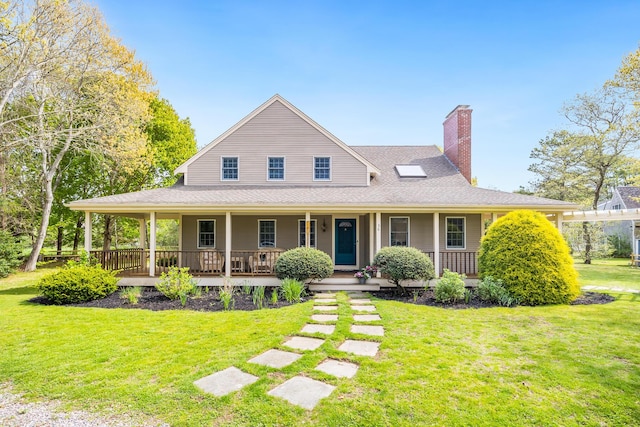 farmhouse-style home featuring a chimney, covered porch, a front yard, and roof with shingles