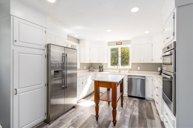 kitchen featuring sink, white cabinetry, appliances with stainless steel finishes, and wood-type flooring