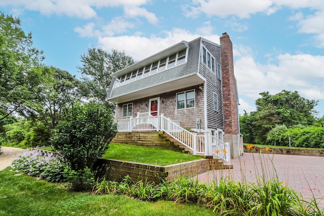 view of front of house featuring a patio and a front lawn