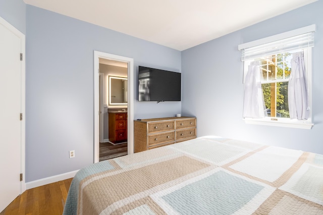 bedroom featuring hardwood / wood-style flooring and ensuite bathroom