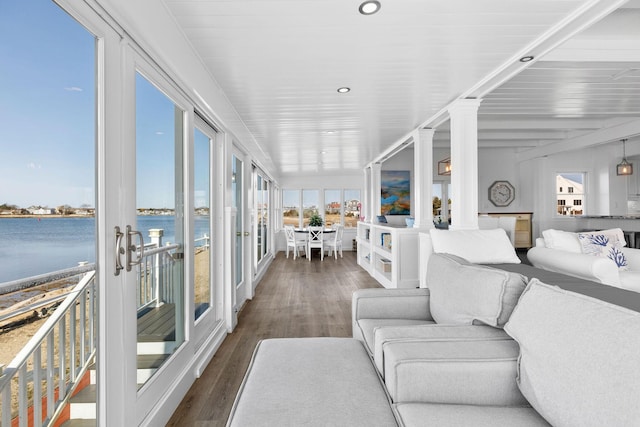 sunroom with a wealth of natural light and a water view