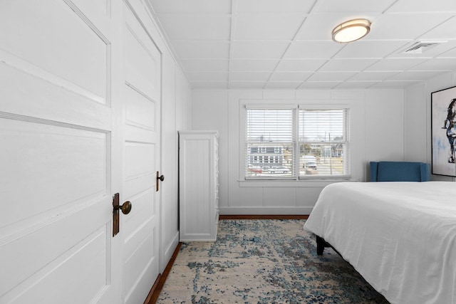 bedroom with a paneled ceiling and visible vents