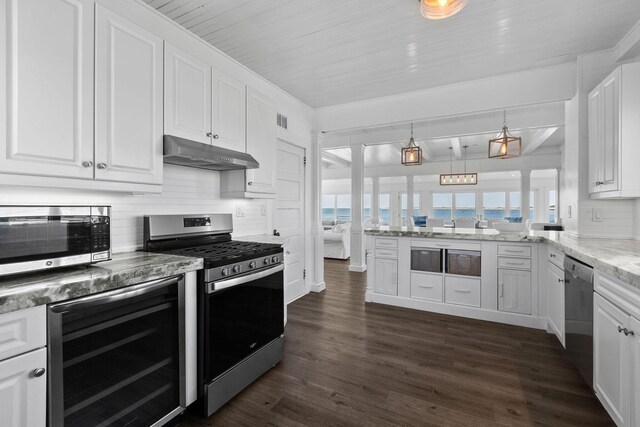 kitchen featuring white cabinetry, appliances with stainless steel finishes, under cabinet range hood, and beverage cooler