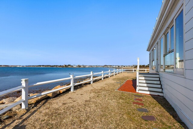 view of yard with a water view and fence