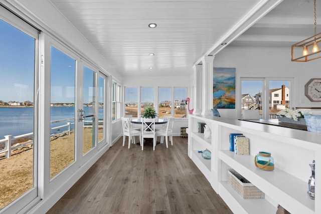 sunroom featuring a water view