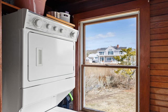 washroom featuring stacked washer / dryer and laundry area
