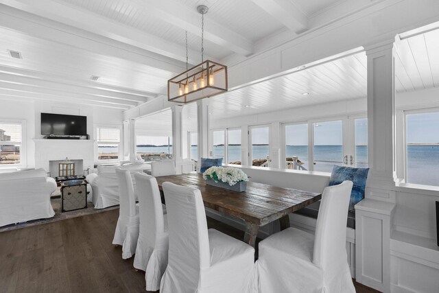 dining space featuring a water view, visible vents, beamed ceiling, dark wood finished floors, and an inviting chandelier