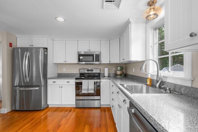 69 Joan Rd, Centerville, MA 02632 - kitchen with stainless steel appliances, white cabinets, light wood finished floors, light countertops, and recessed lighting