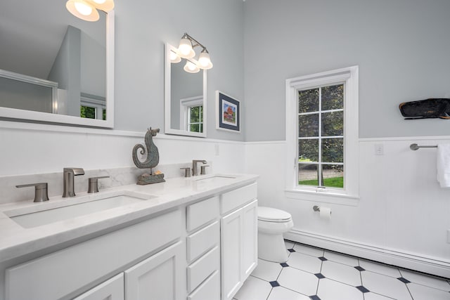 69 Joan Rd, Centerville, MA 02632 - full bath with baseboard heating, a wainscoted wall, double vanity, tile patterned floors, and an enclosed shower